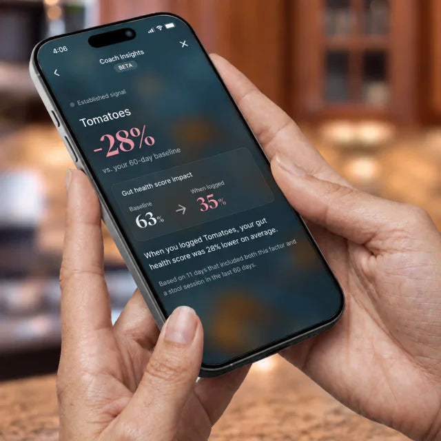 A hand holding a phone showing a Throne Coach insight: tomatoes, minus 28 percent versus the 60-day baseline