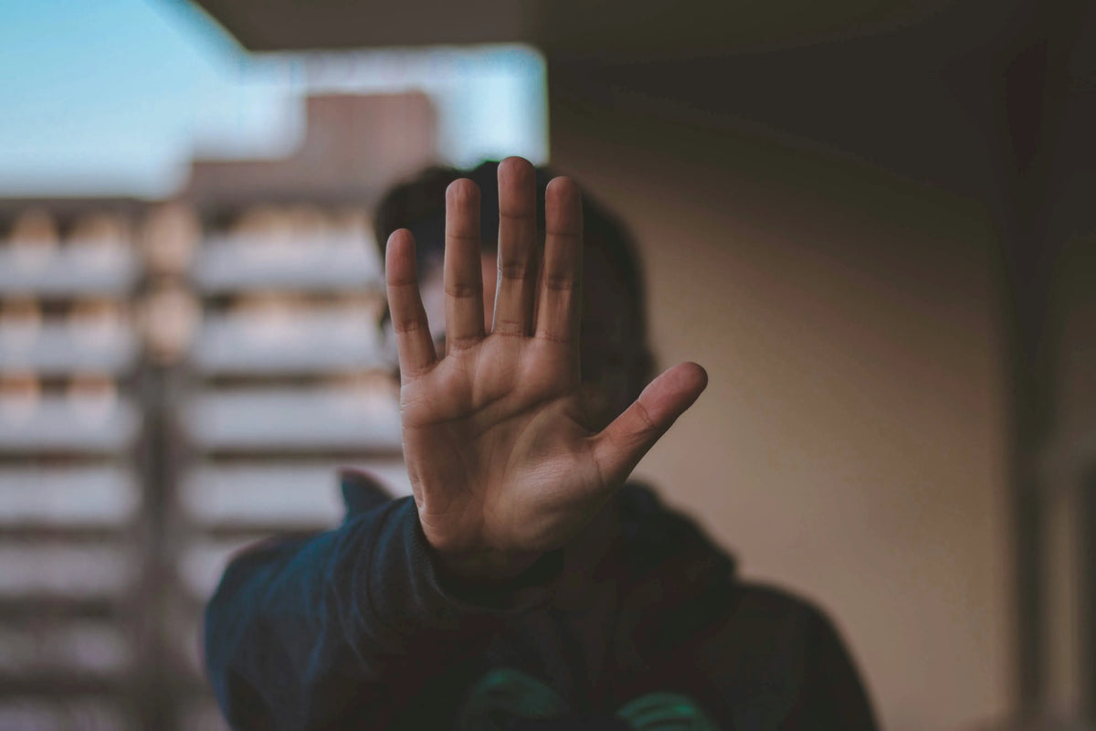 a man holding up his hand to indicate the number 5