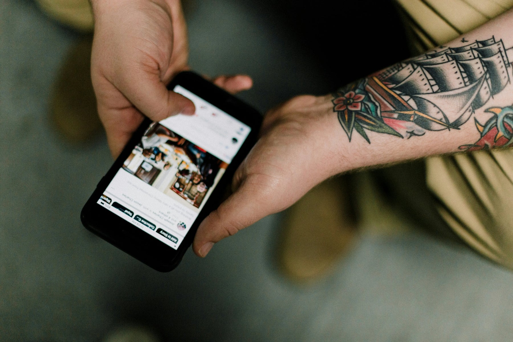 Person scrolling on a smartphone while seated