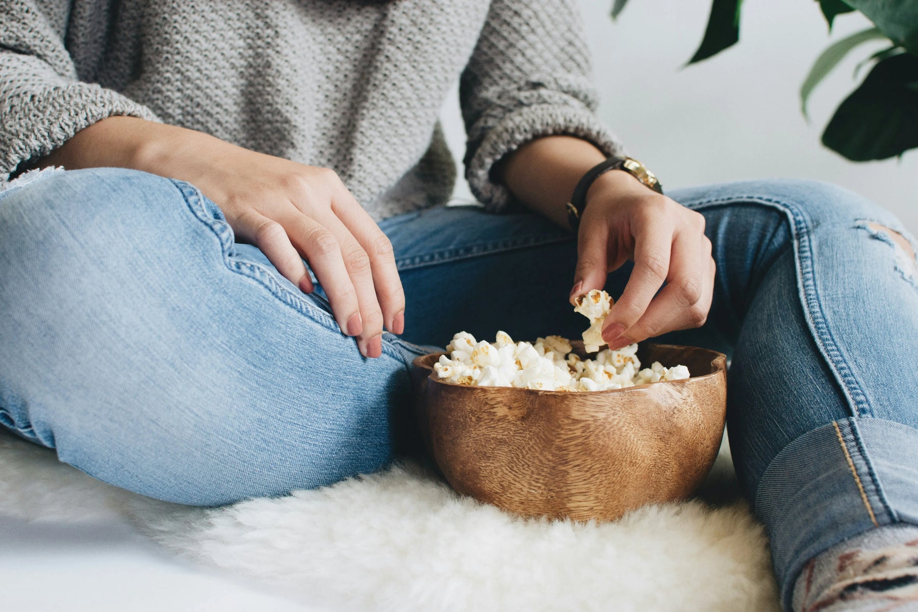 woman sitting on the ground eating popcorn