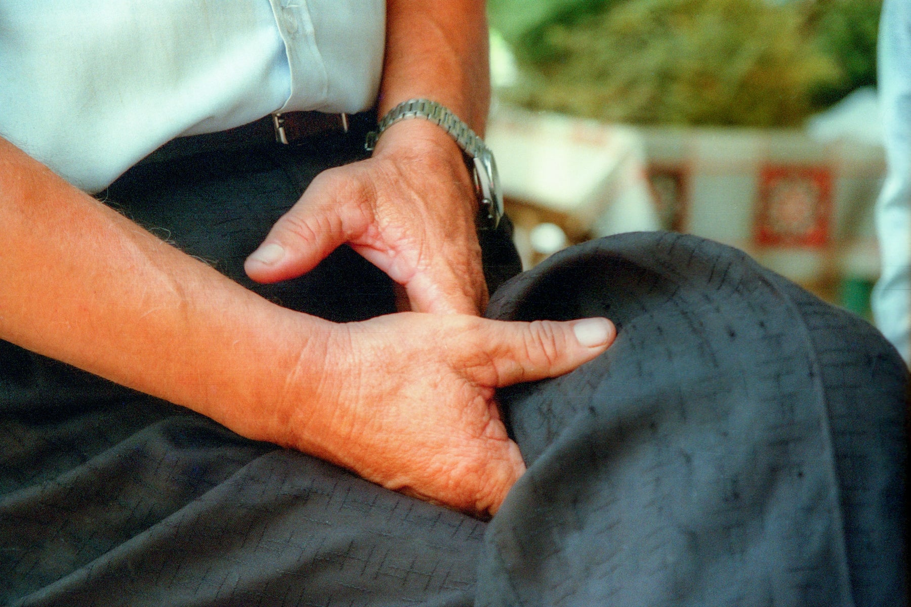 woman sitting with her hands folded over her lap, indicating discomfort