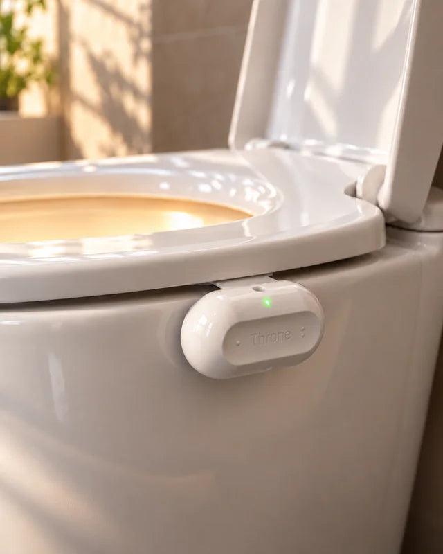 Throne installed on the side of a toilet bowl under the seat, its status light glowing